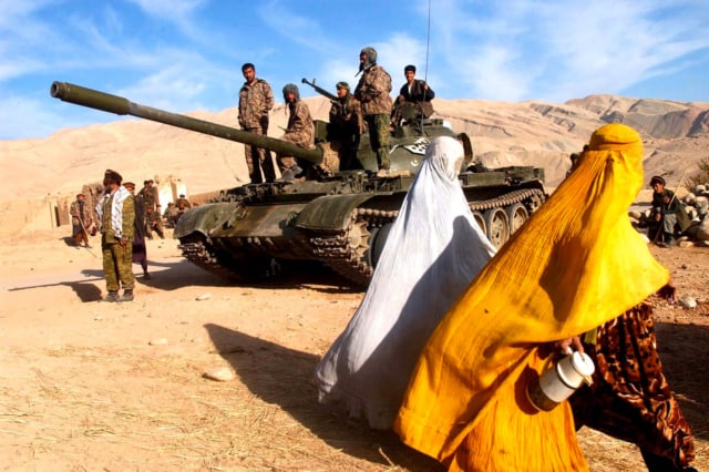 Deux femmes franchissent la ligne de front contrôlée par les talibans, Afghanistan, novembre 2001 ©James Hill