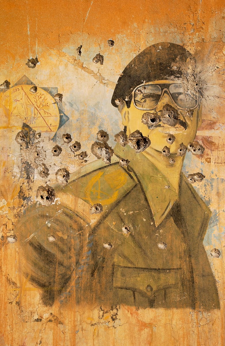 Portrait mural de Saddam Hussein perforé de balles par les forces américaines, Irak, avril 2003 ©James Hill