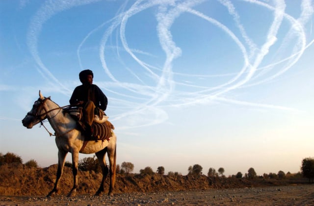 Un homme regarde les avions américains dans le ciel de Kalakata, Ville de Deshtikala Afghanistan, novembre 2001 JH003 ©James Hill