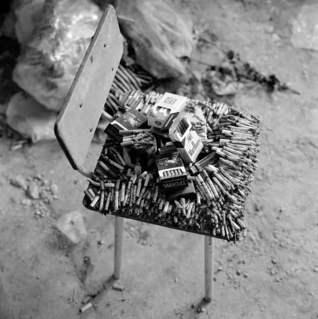 Cigarettes brûlant sur une chaise en signe de respect pour les hommes exécutés dans cette salle de classe de l’école de Beslan, Russie, 2004 ©James Hill